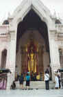 Devotees before a tall statue of the Buddha